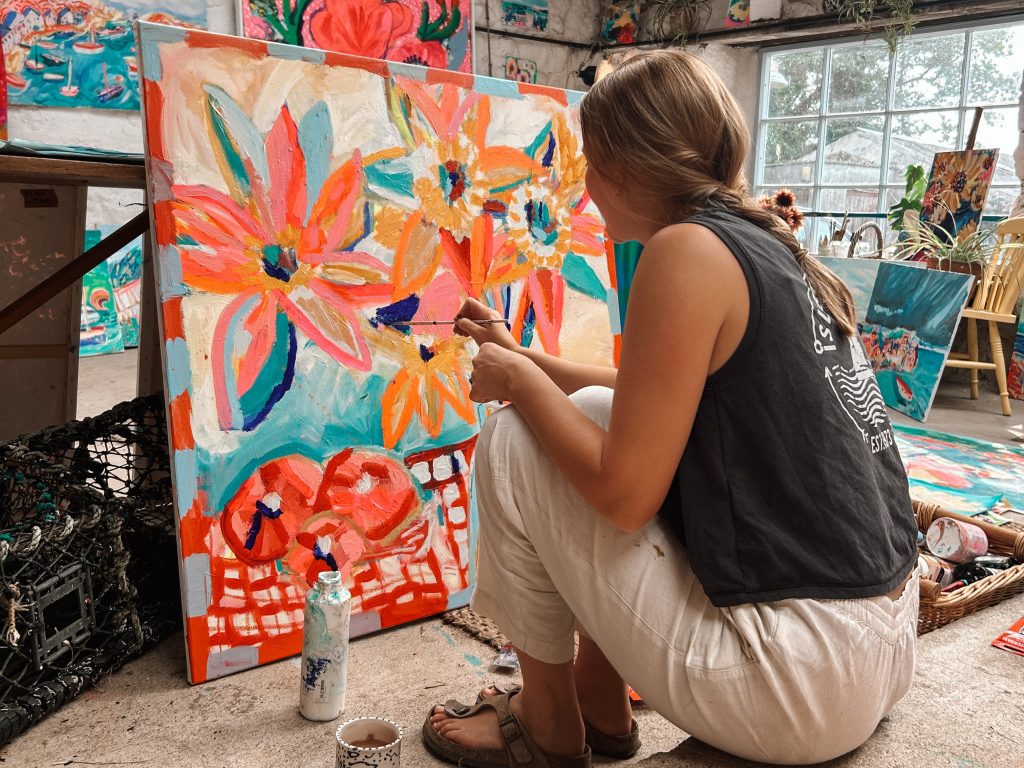 Artist Kimmy Hussey painting a still life on canvas