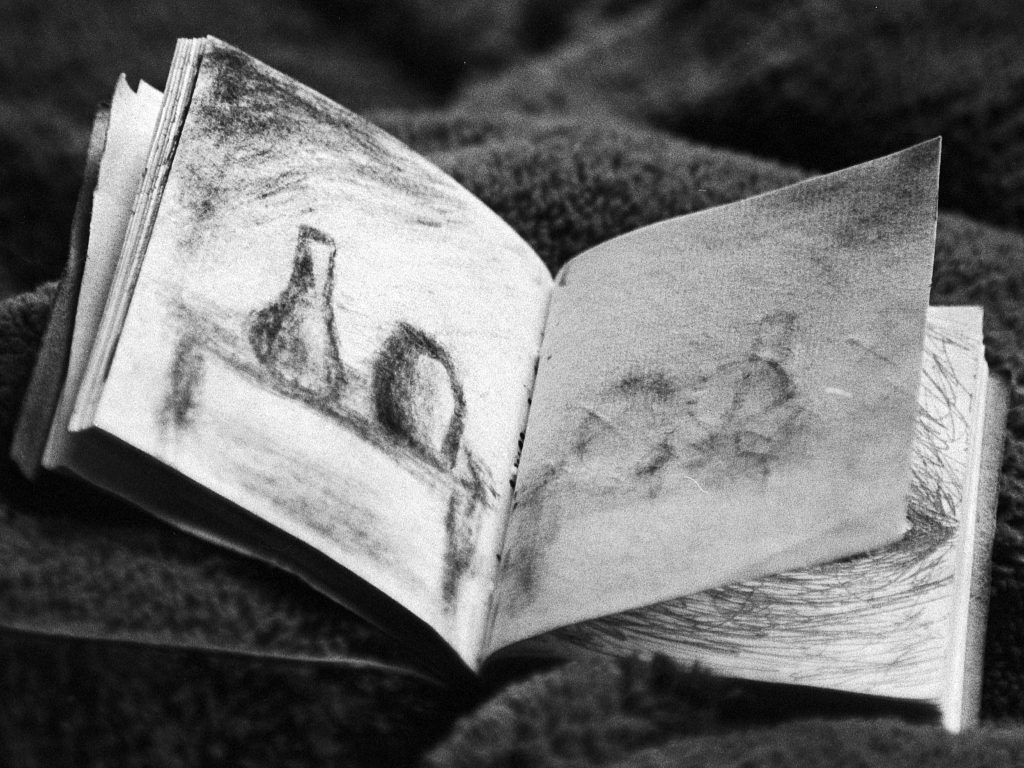 stock image of a sketchbook with a charcoal still life drawing